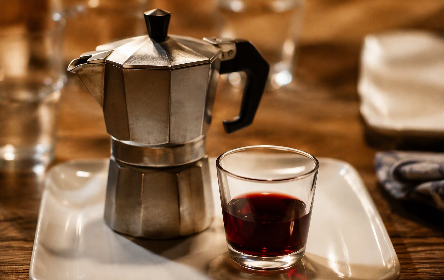 La moka e il vino sul tavolo di legno